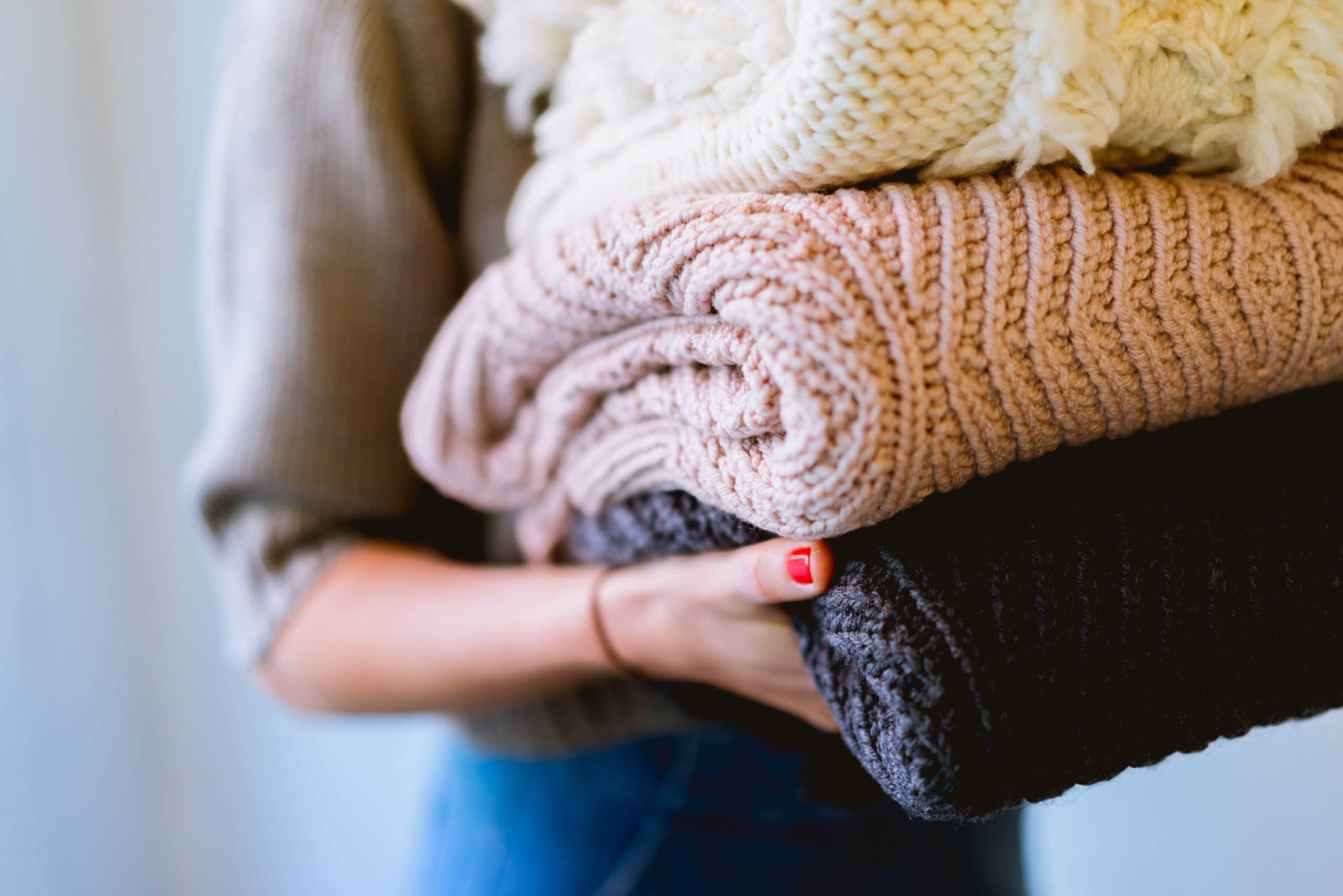 woman donating gently used and near new sweaters